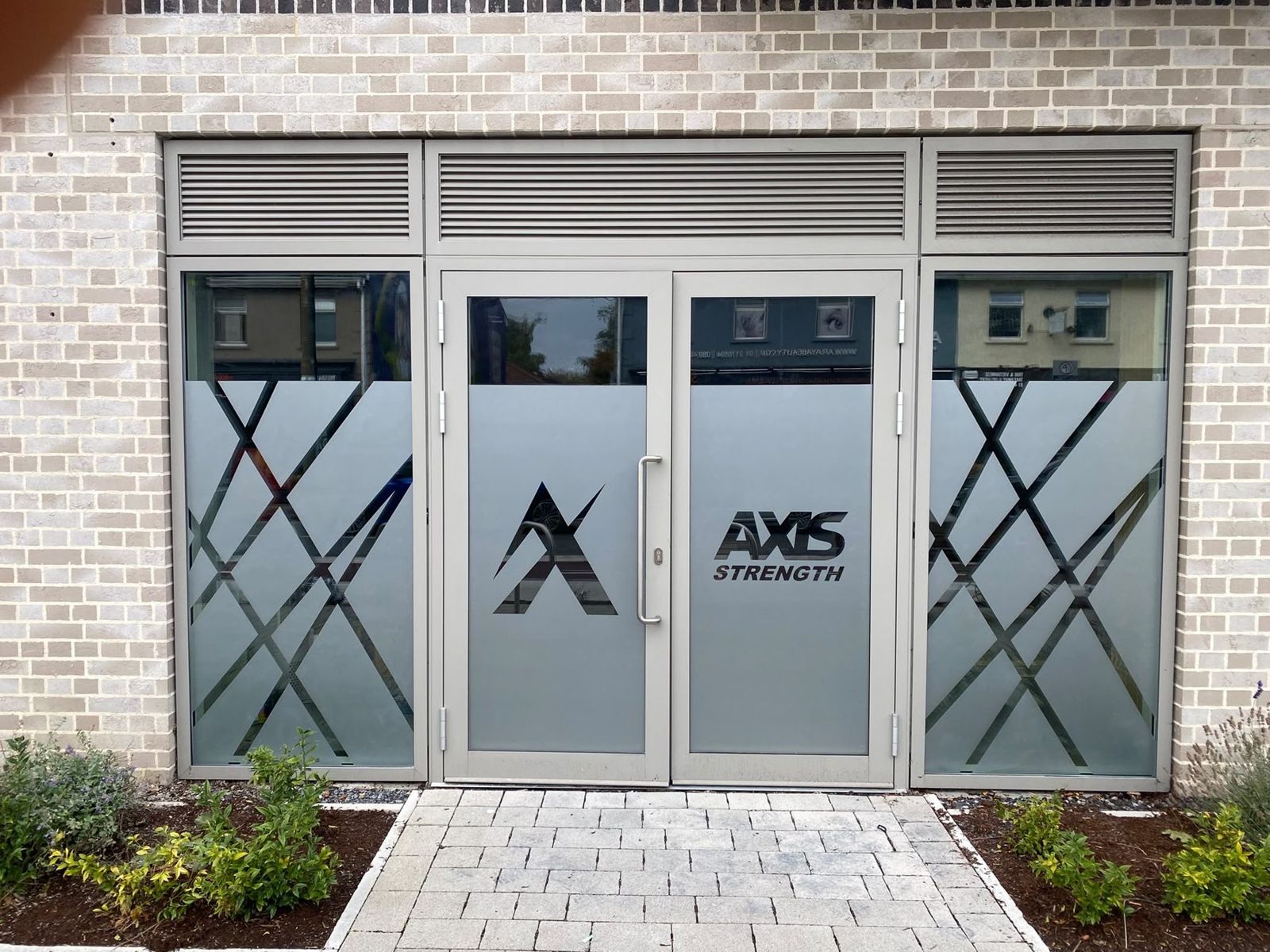 Axis logo and frosted window graphics across a studio shopfront