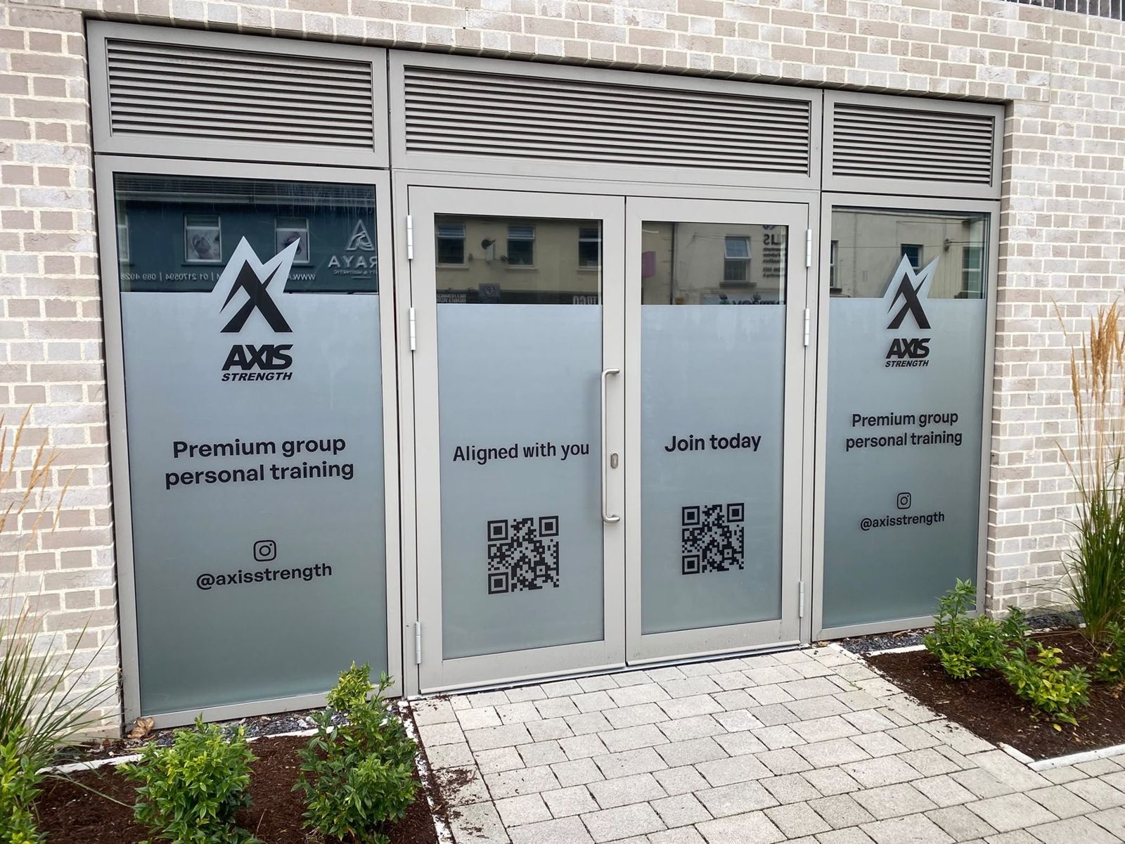 Axis shopfront with frosted door vinyls reading Premium group personal training, Aligned with you and Join today
