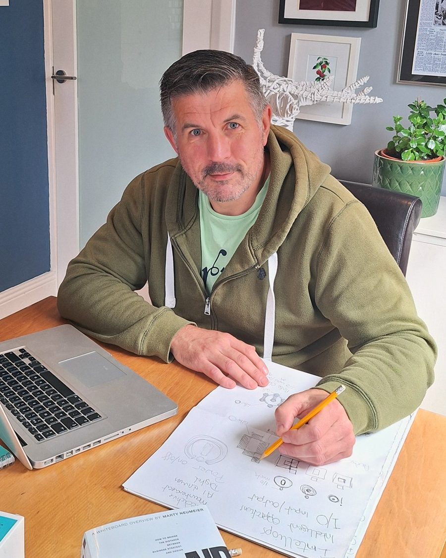 Barry O'Connor at his desk, sketching logo ideas by hand