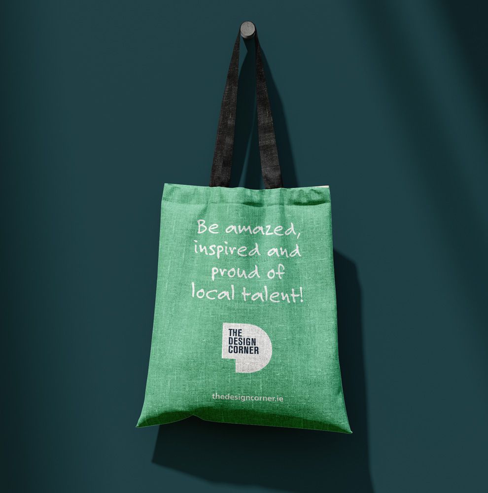 Green tote bag printed with Be amazed, inspired and proud of local talent