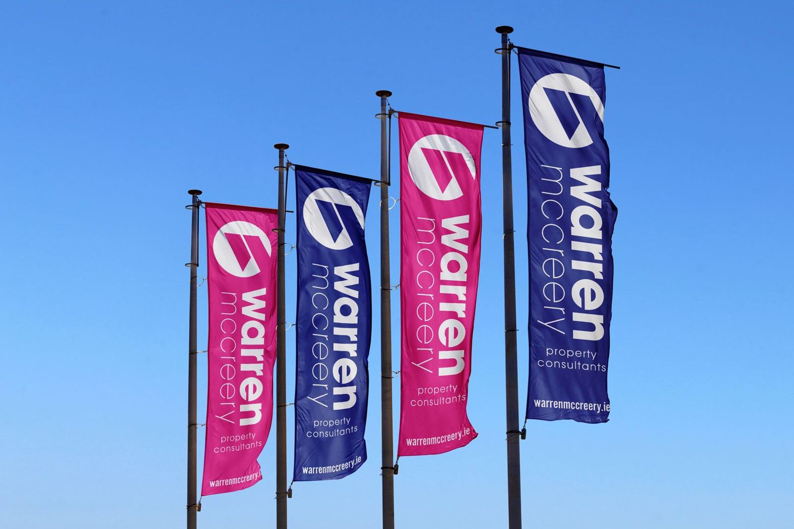 Row of Warren McCreery flags in pink and purple